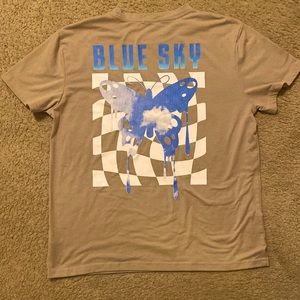 A tan romwe shirt with a blue sky design on it, along with butterflies.